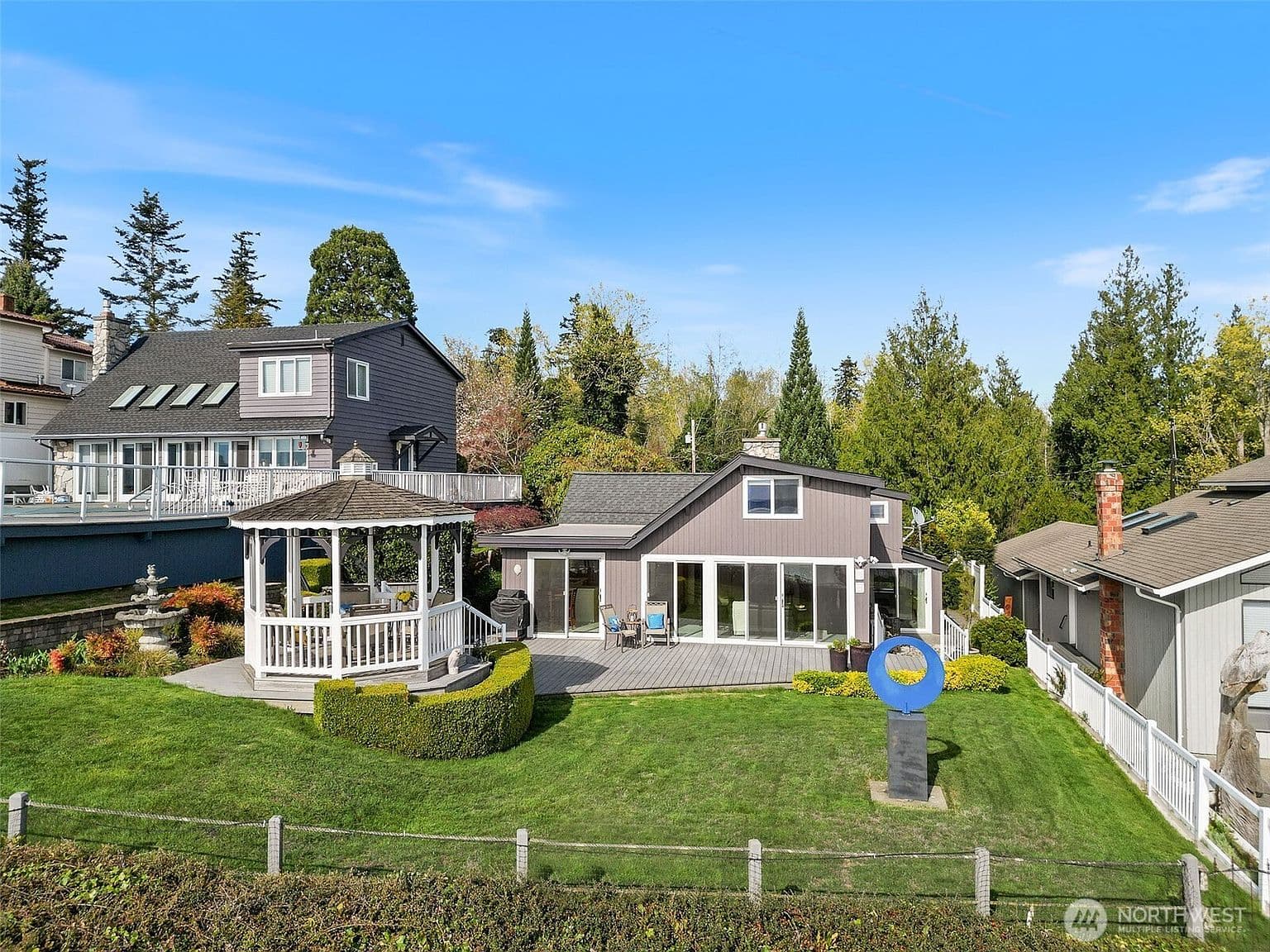 Exterior front — white home with wraparound porch and mature garden